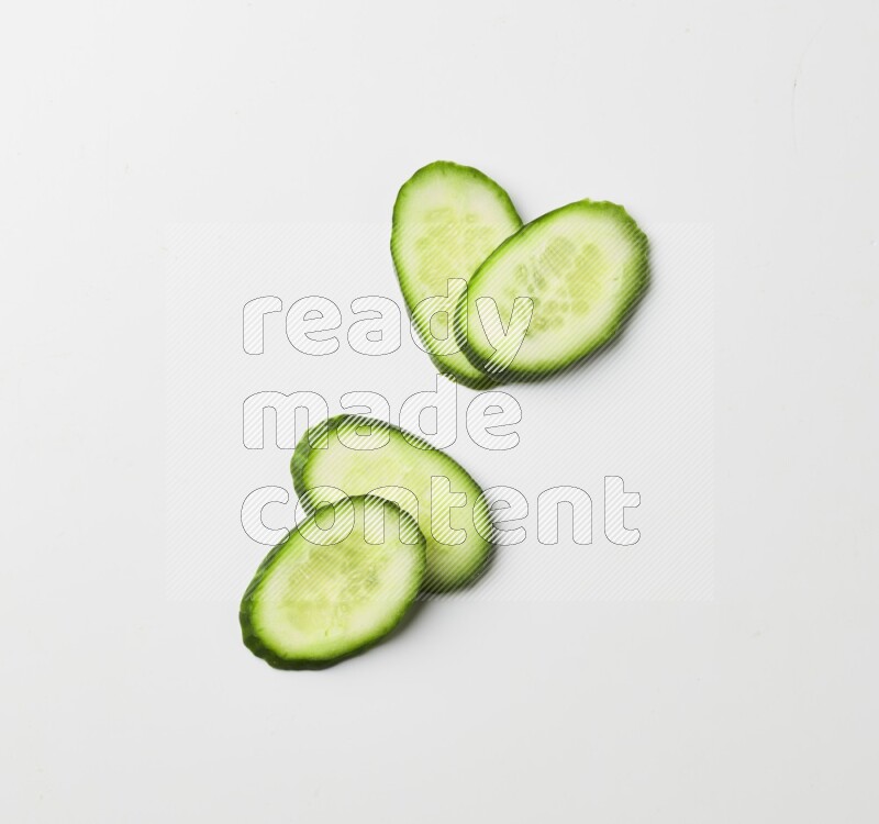 Multiple cucumber slices on white background