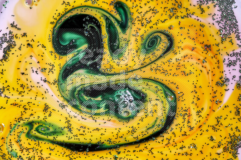 A close-up of sparkling green glitter scattered on swirling yellow and green background