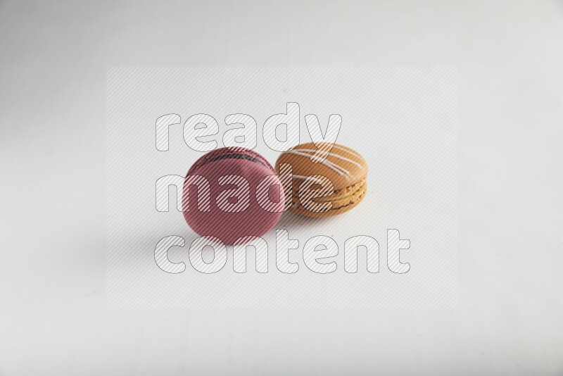45º Shot of of two assorted Brown Irish Cream, and Red Cherry macarons on white background
