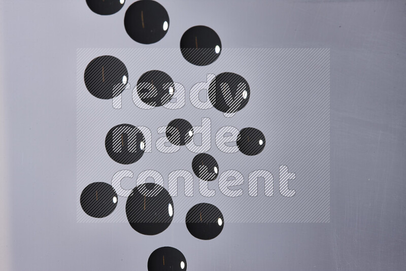 Close-ups of abstract black paint droplets on the surface