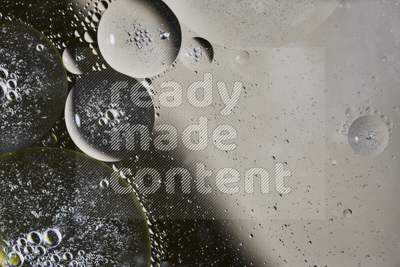 Close-ups of abstract oil bubbles on water surface in shades of brown, black and yellow