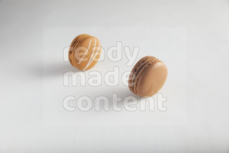 45º Shot of of two assorted Brown Irish Cream, and Brown Coffee macarons  on white background