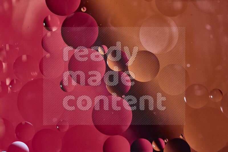 لقطات مقربة لفقاعات من الزيت على سطح الماء باللون الأحمر والبرتقالي