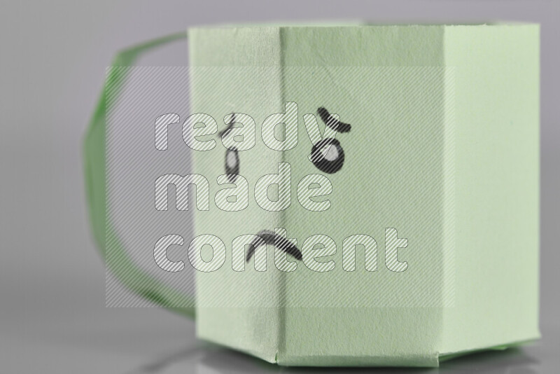 Origami cup on grey background