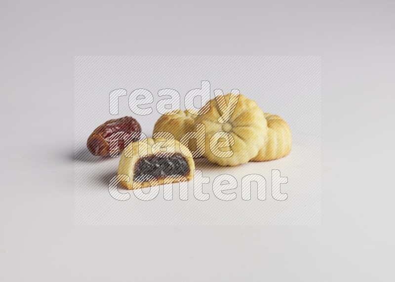 Four Pieces of Maamoul filled with date one of them is cut direct on white background