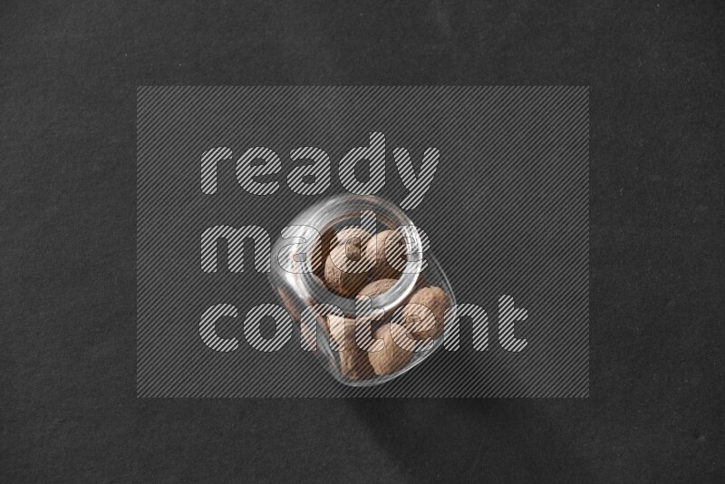 جوزة الطيب في وعاء زجاجي علي خلفية سوداء