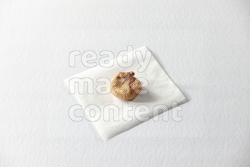 A dried fig on a piece of paper on a white background in different angles