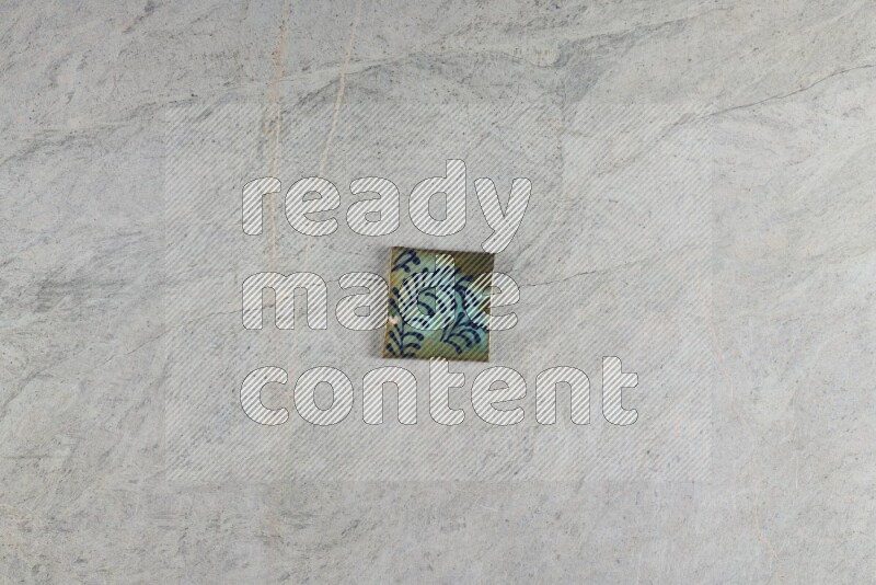A decorative pottery coaster on grey marble background