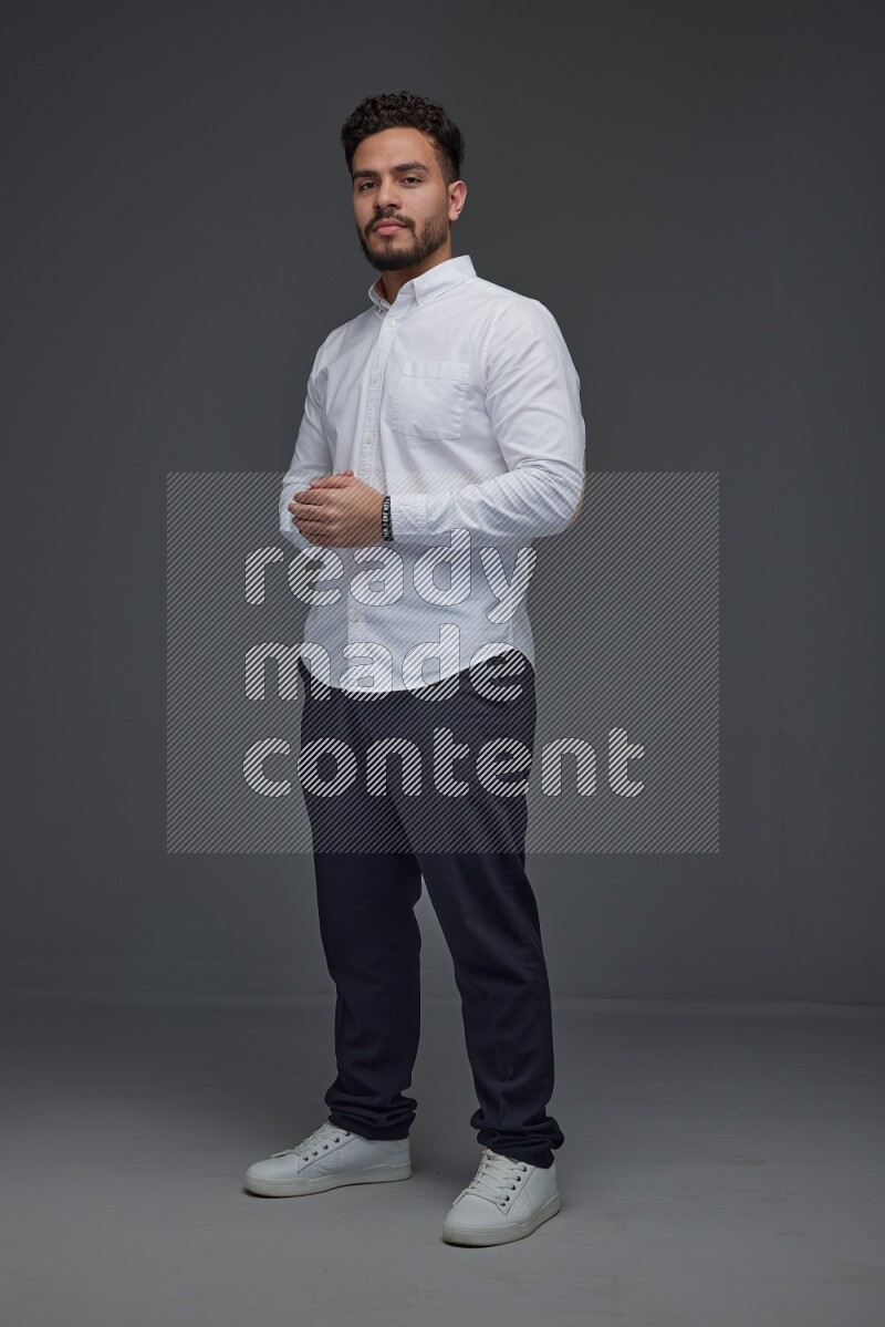 A man wearing smart casual making multi stand poses  eye level on a gray background