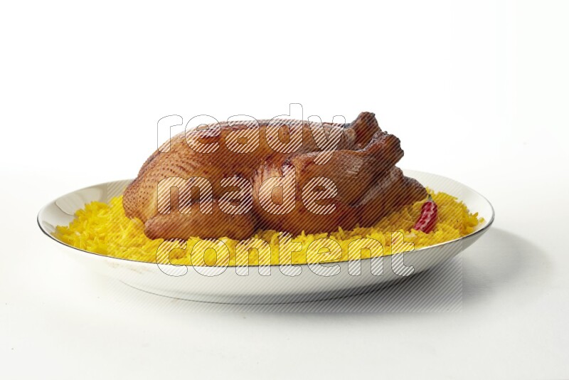 yellow  basmati Rice with kabsa chicken pieces on a white plate with a silver rim direct on white background