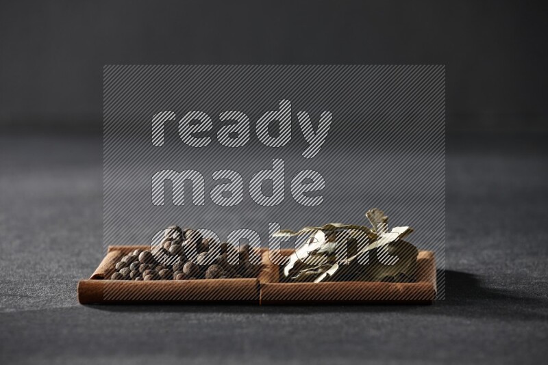 2 squares of cinnamon sticks full of allspice and bay laurel leaves on black flooring