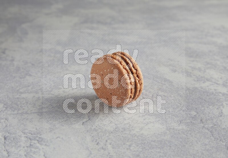 45º Shot of Brown Hazelnuts macaron on white  marble background