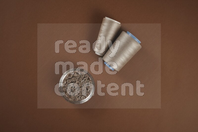 A brown collection of sewing and tailoring tools arranged on a brown background