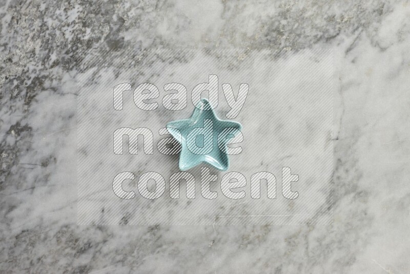 A colored pottery star plate on grey marble background