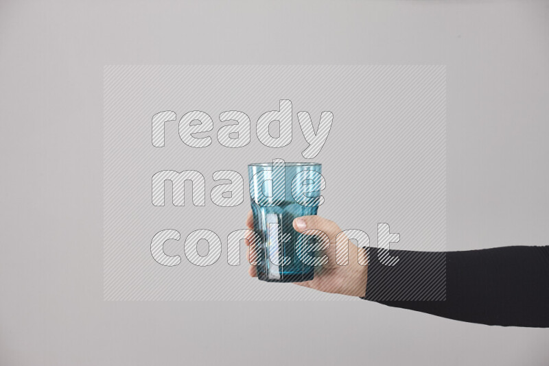 امرأة ترتدي عباءة سوداء تحمل أدوات زجاجية مختلفة في أوضاع متعددة