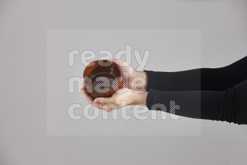 A woman in black abaya holding different pottery essentials in different positions