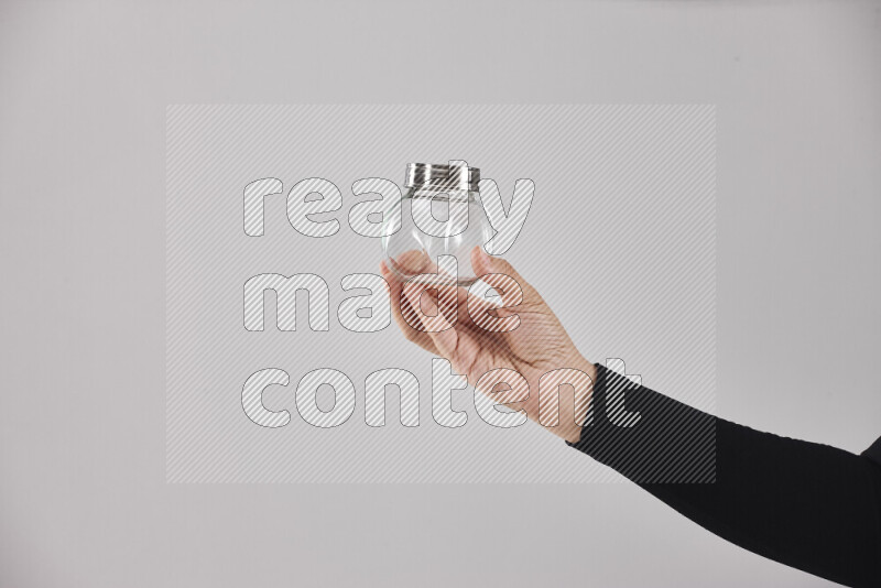 امرأة ترتدي عباءة سوداء تحمل أدوات زجاجية مختلفة في أوضاع متعددة