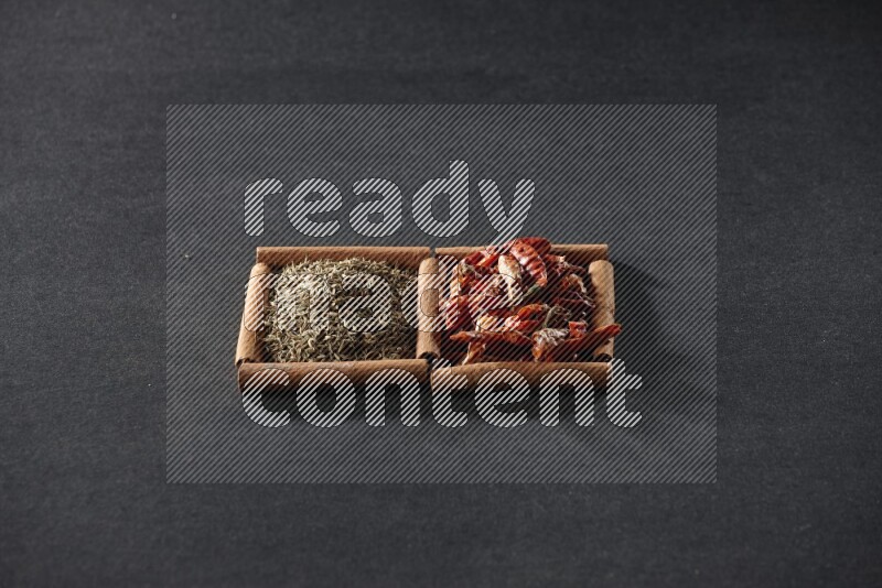 مربعان من أعواد القرفة ممتلئان بالفلفل الحار المجفف وحبوب الكمون علي خلفية سوداء