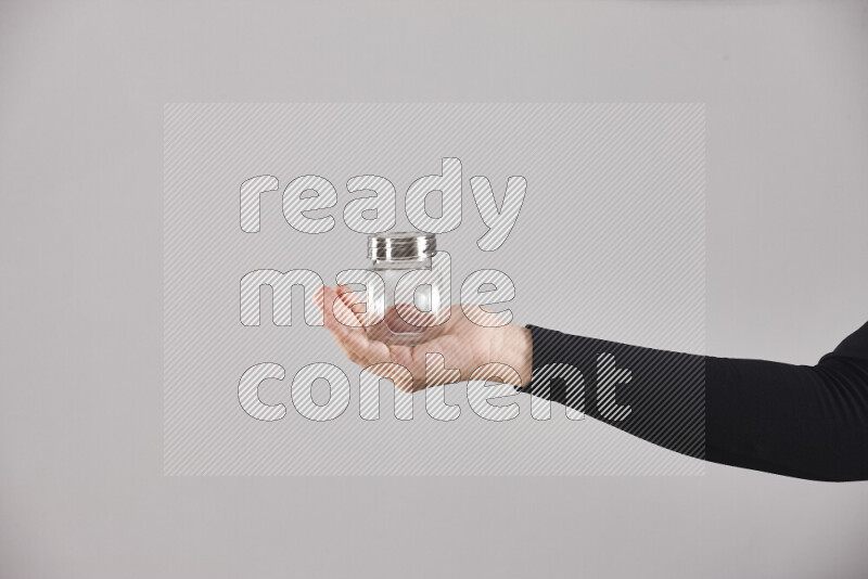 امرأة ترتدي عباءة سوداء تحمل أدوات زجاجية مختلفة في أوضاع متعددة