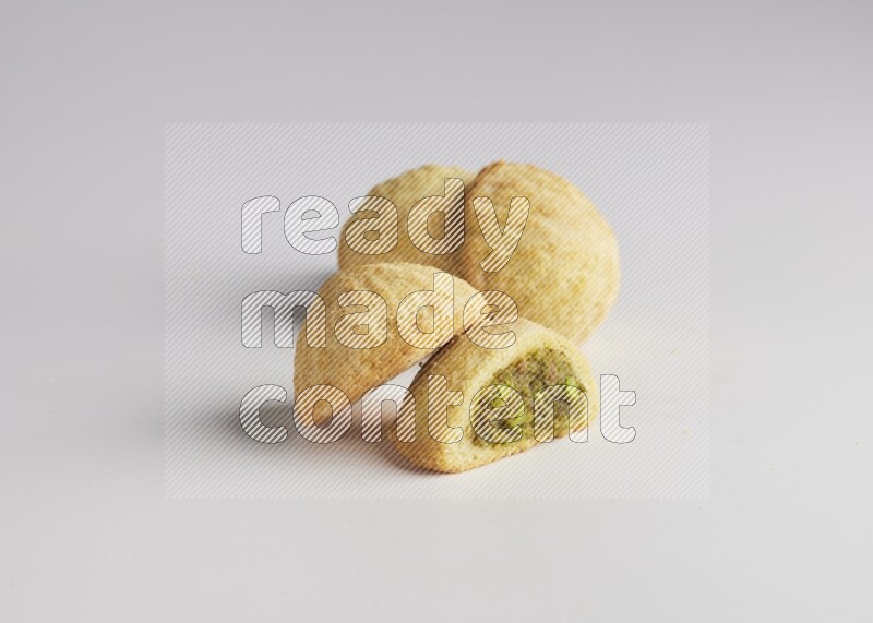 Four Pieces of Maamoul filled with pistachio  paste one of them is cut direct on white background