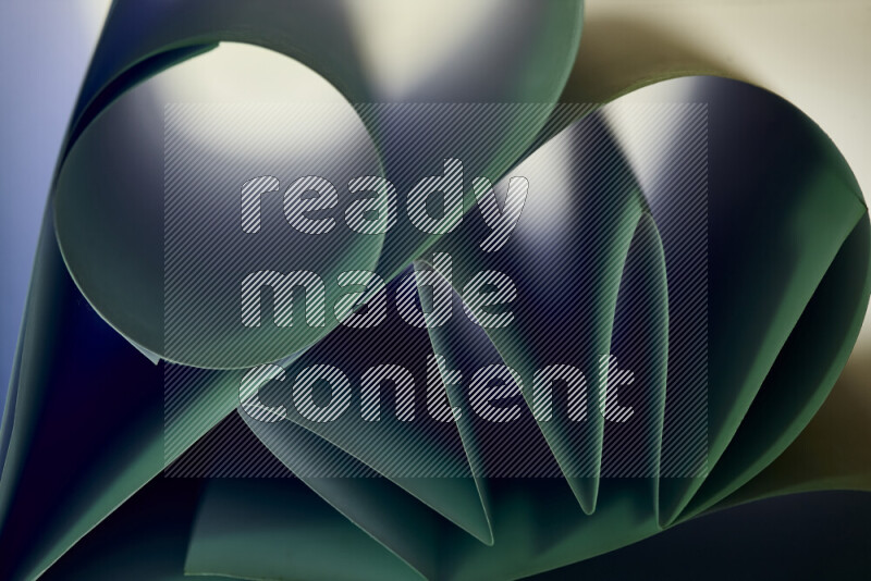 An artistic display of paper folds creating a harmonious blend of geometric shapes, highlighted by soft lighting in green tones