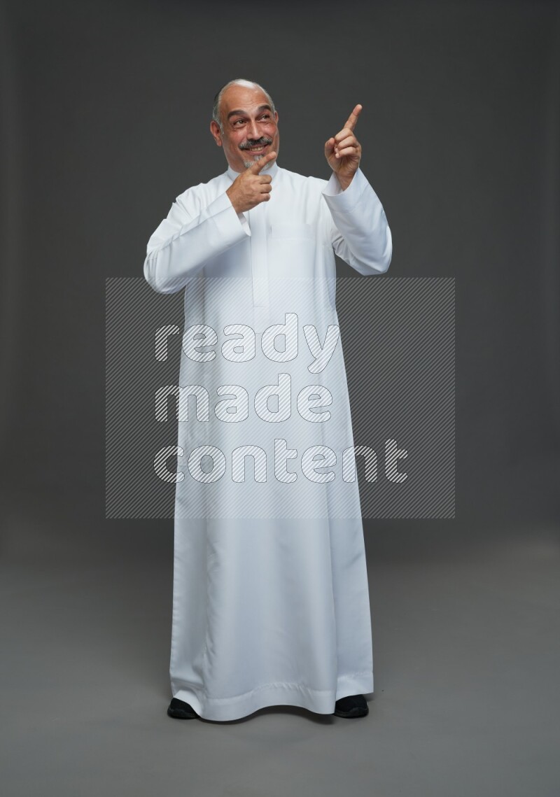 Saudi man without shomag Standing Interacting with the camera on gray background