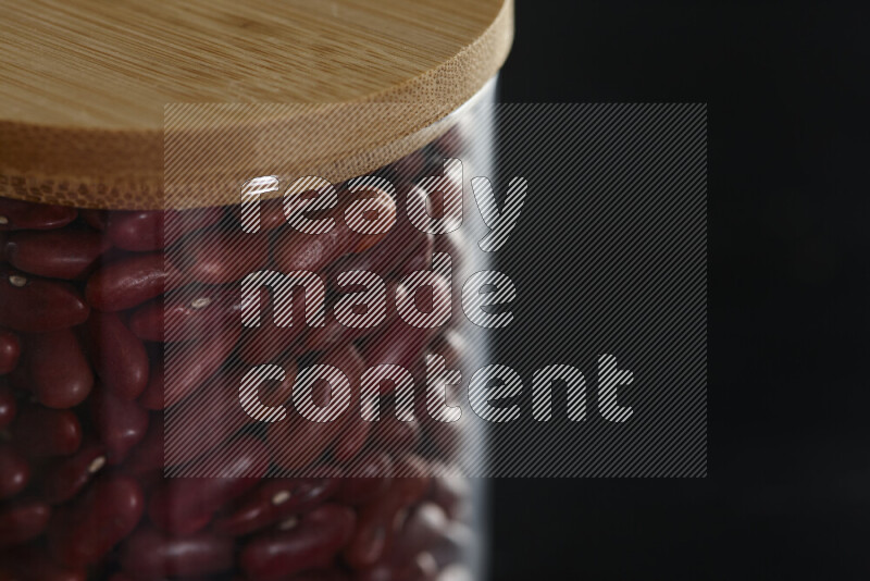 Red kidney beans in a glass jar on black background