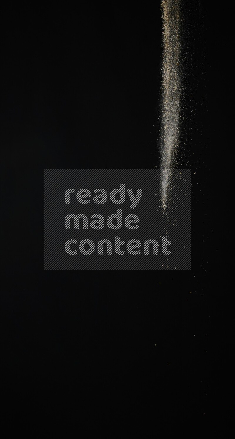 A side view of brown powder explosion on black background