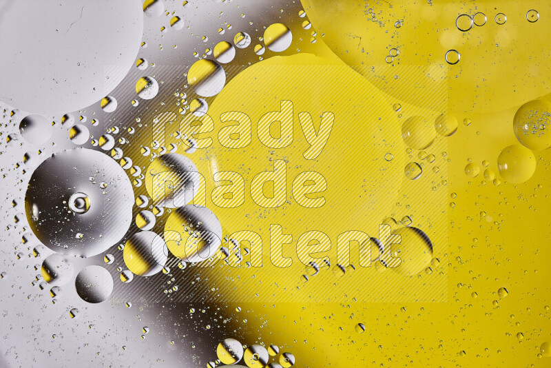 Close-ups of abstract oil bubbles on water surface in shades of white and yellow