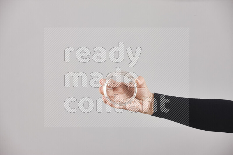 امرأة ترتدي عباءة سوداء تحمل أدوات زجاجية مختلفة في أوضاع متعددة