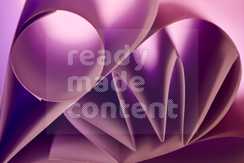 An artistic display of paper folds creating a harmonious blend of geometric shapes, highlighted by soft lighting in purple tones