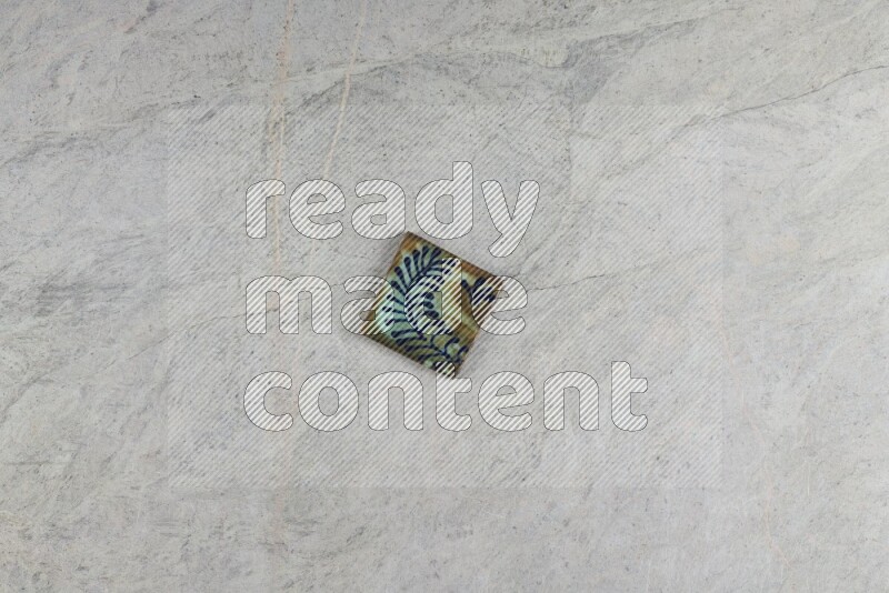A decorative pottery coaster on grey marble background