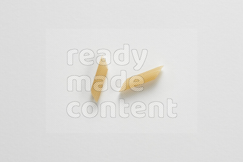 Mini penne pasta on white background