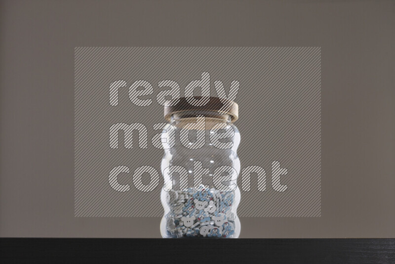 Buttons in a glass jar on black background