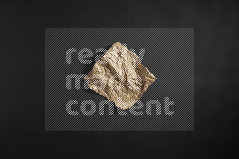 Crumpled craft paper on black background
