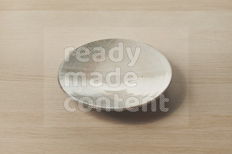 A multicolored pottery plate on light wooden background