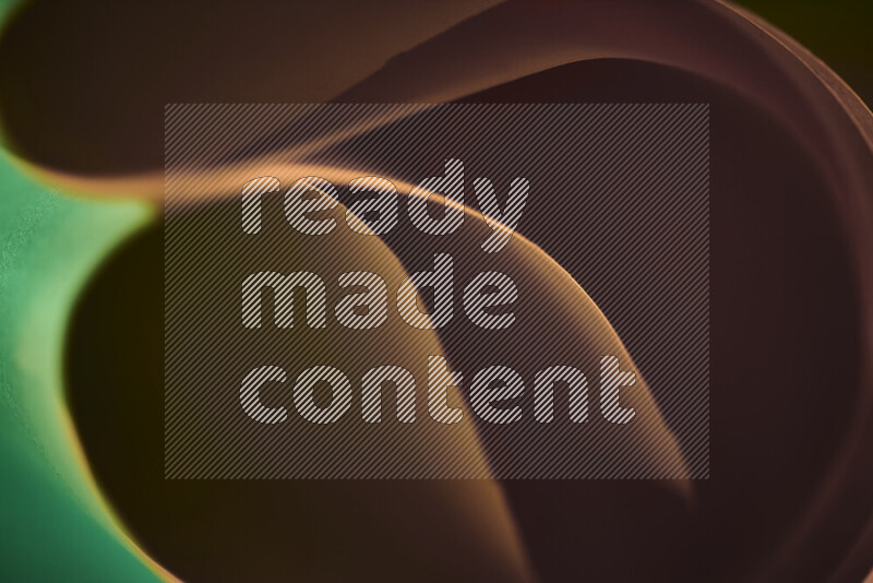 An abstract art piece displaying smooth curves in green and orange gradients created by colored light