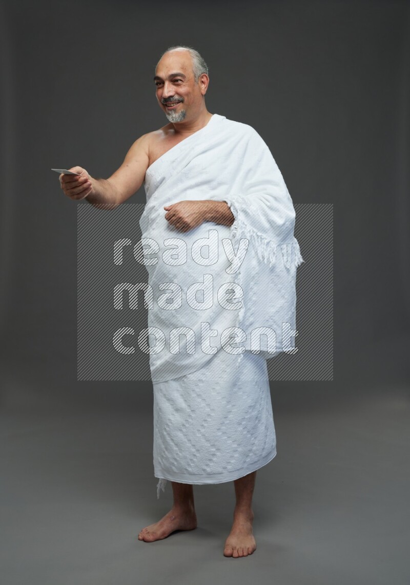 A man wearing Ehram Standing holding ATM card on gray background
