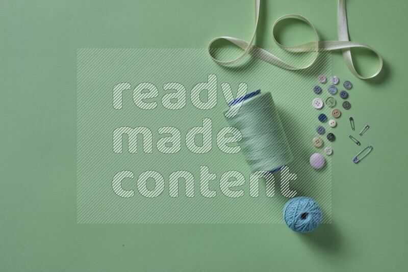 مجموعة من أدوات الخياطة والتفصيل خضراء اللون على خلفية خضراء