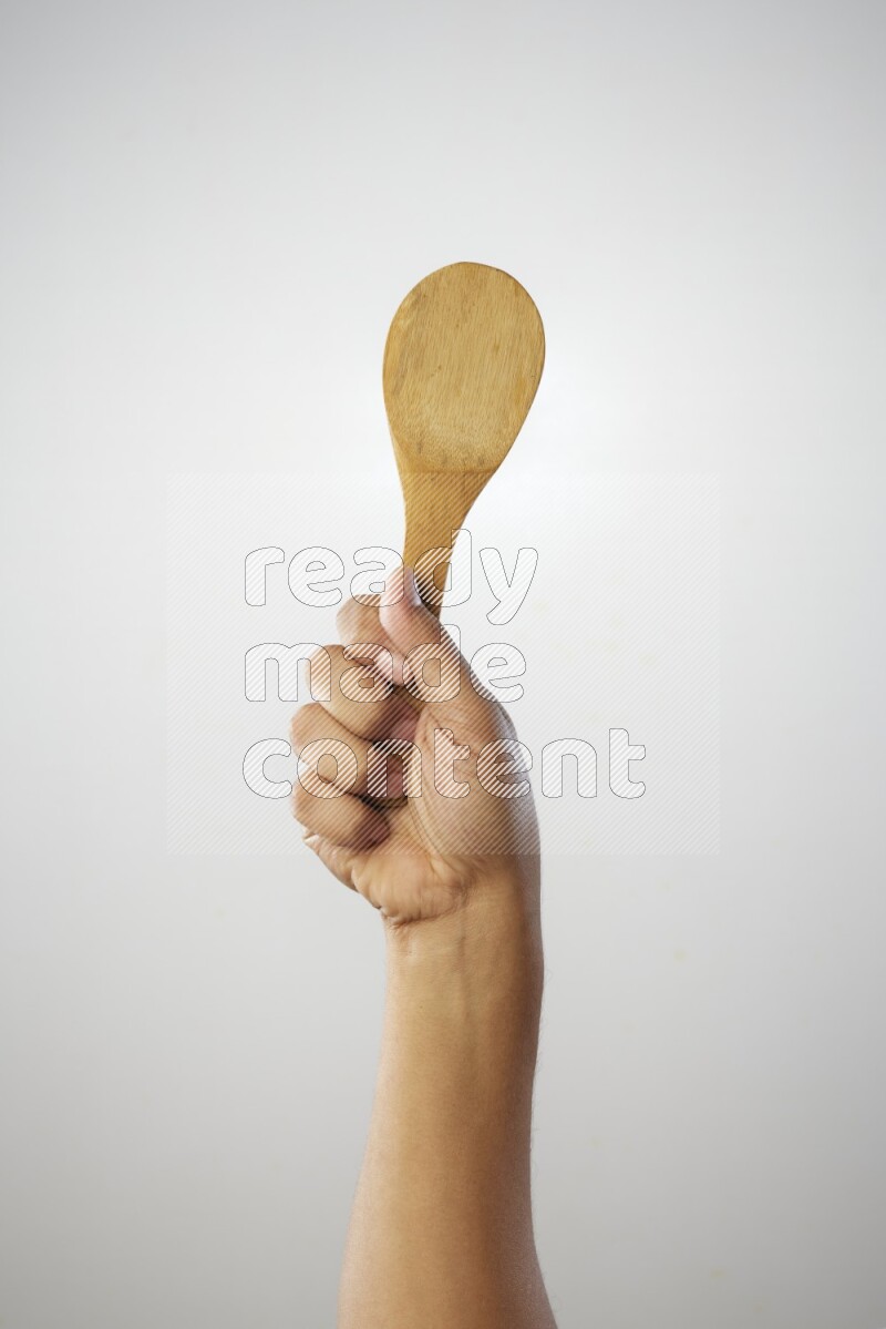 Male Hand Holding Wooden spoon on white background