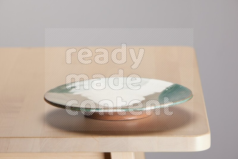 multi-colored pottery Plate on a wooden table edge