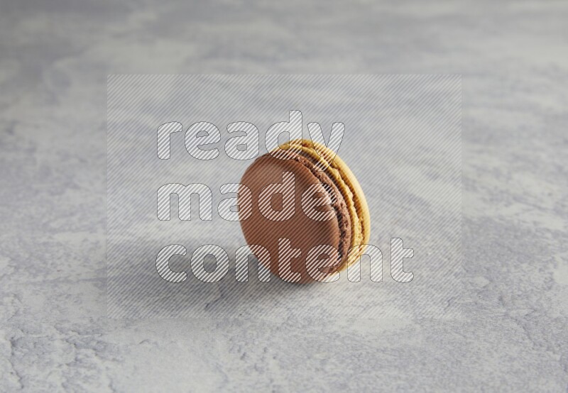 45º Shot of Yellow and Brown Chai Latte macaron on white  marble background