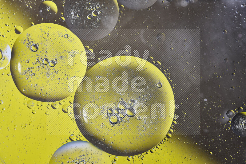 Close-ups of abstract oil bubbles on water surface in shades of yellow and brown