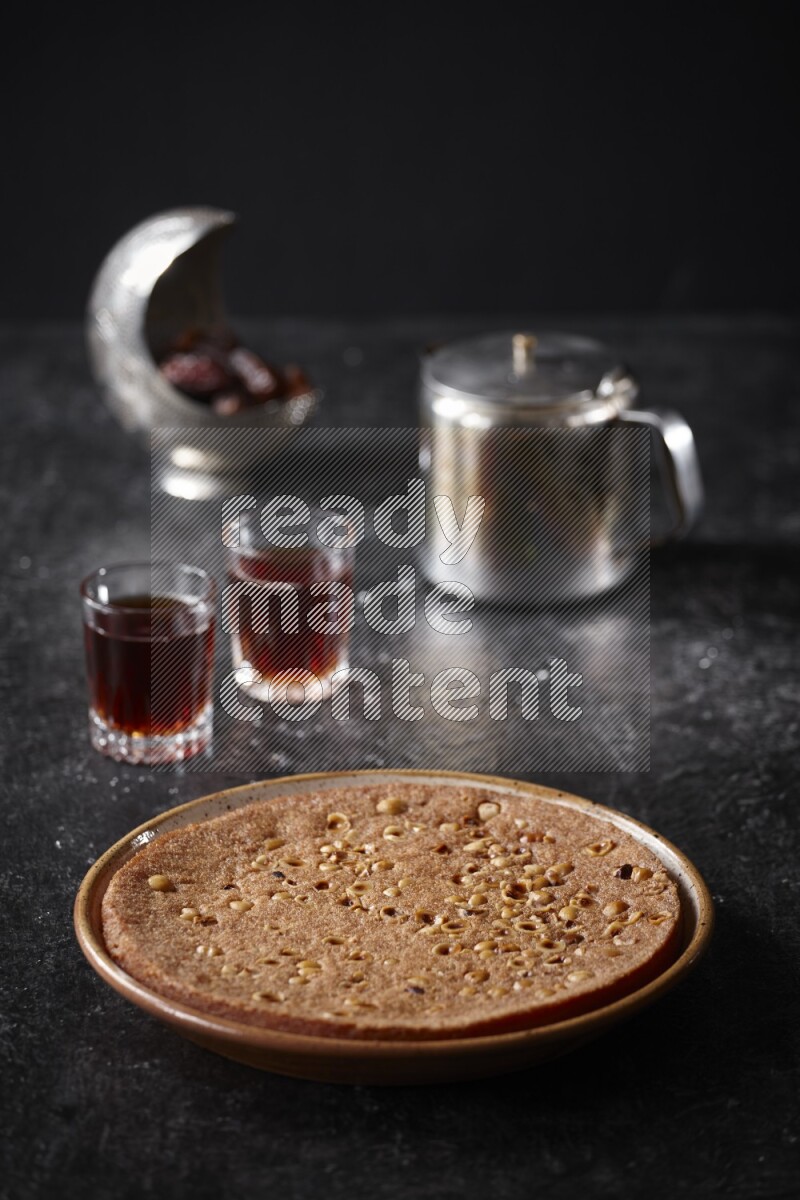 Basbousa with tea in a dark setup