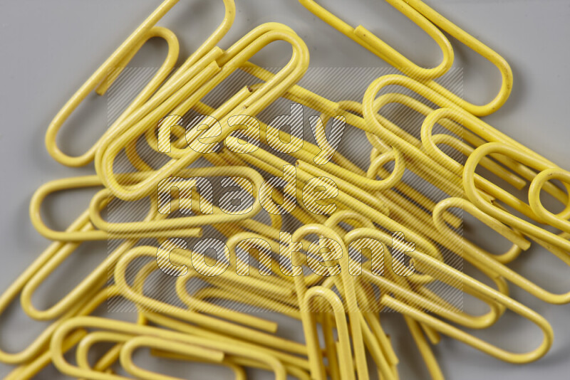 Yellow paper clips isolated on a grey background