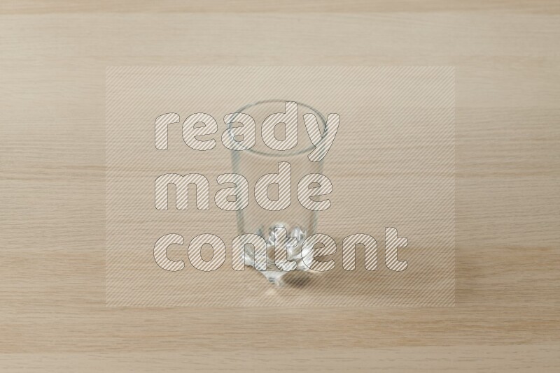 An empty glass cup on light wooden background