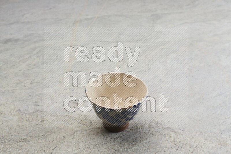 A multicolored pottery bowl on grey marble background