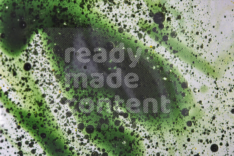 Close-ups of abstract green watercolor drops on oil Surface on white background