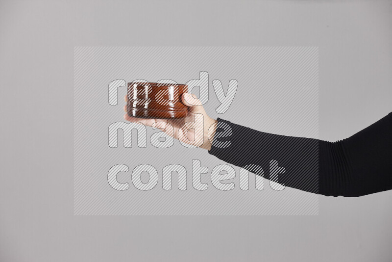 A woman in black abaya holding different pottery essentials in different positions