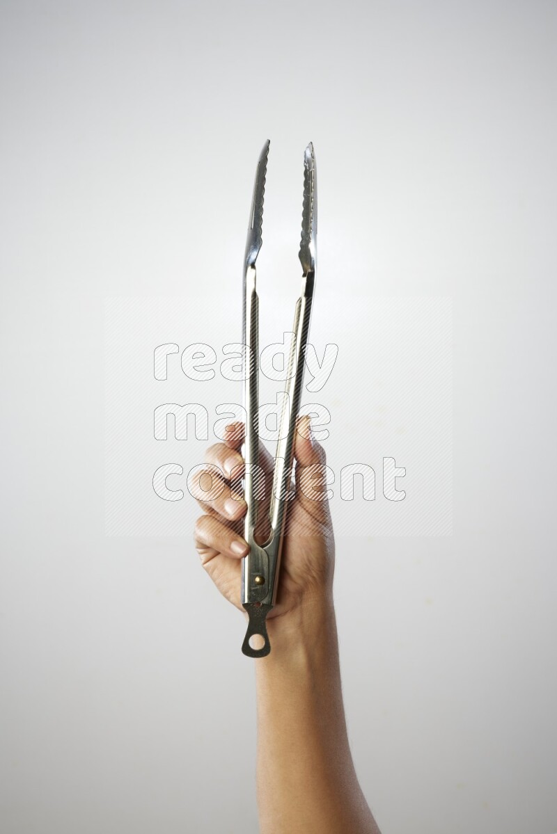 Male Hand Holding Tongs on white background